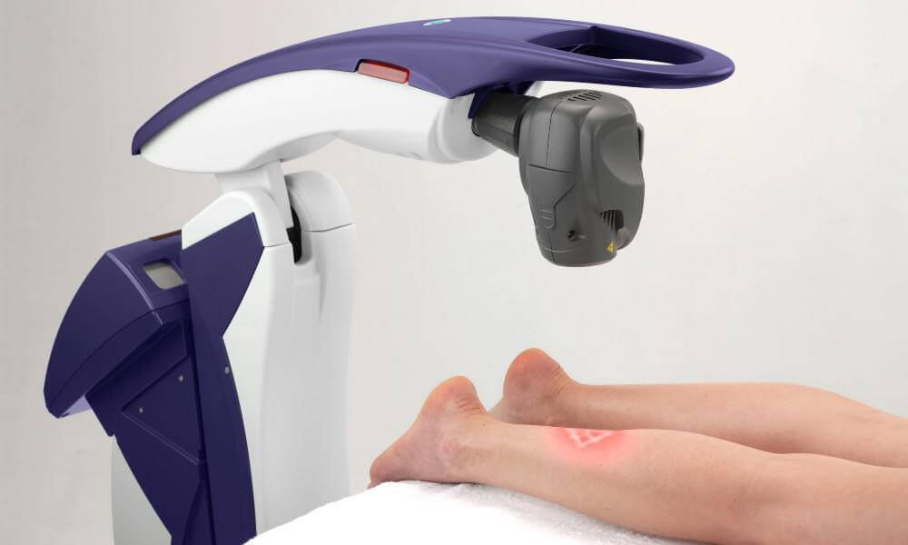 patient laying down on the table while getting healed by a machine