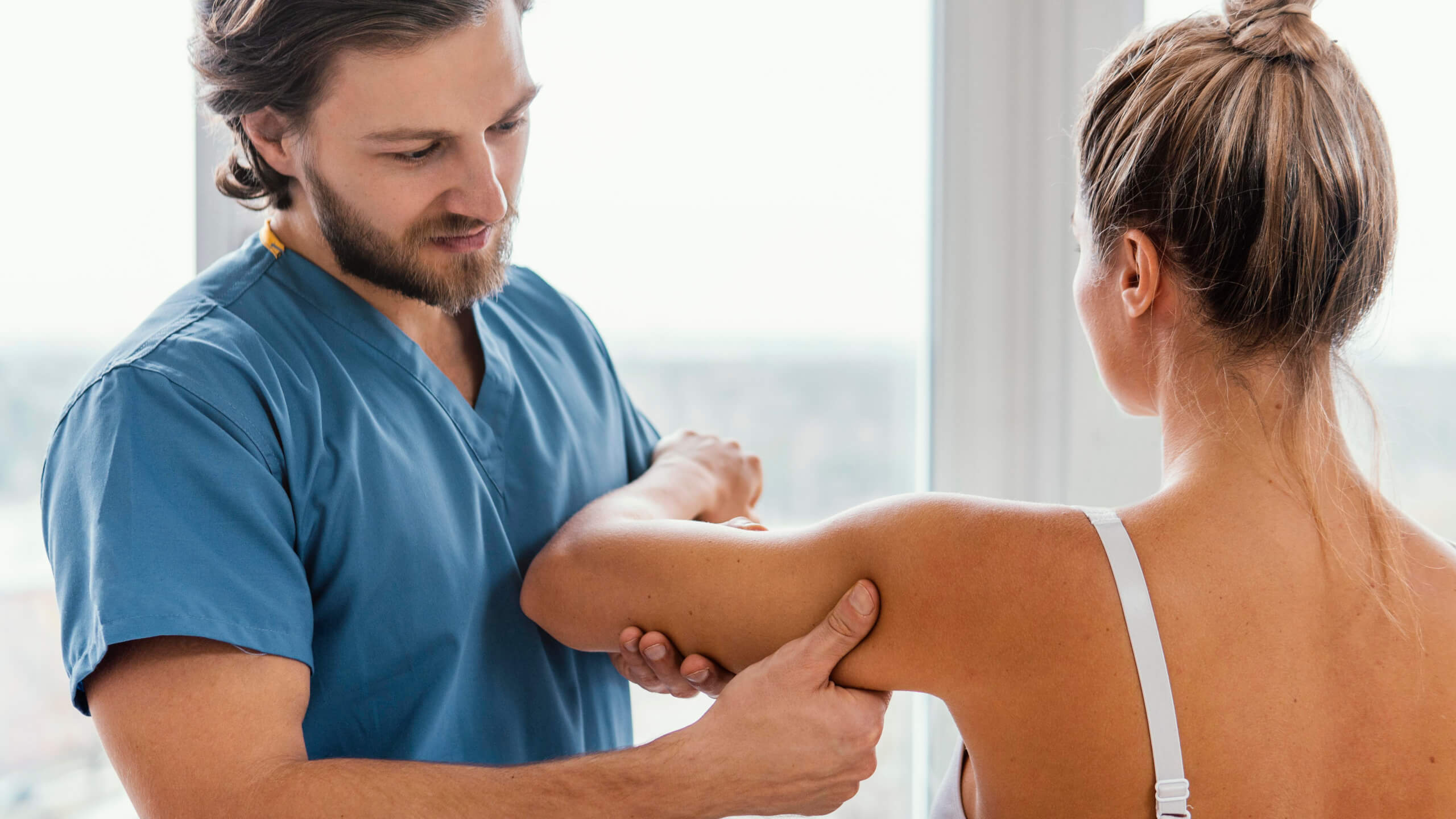 fizioterapevt pregleduje pacienta