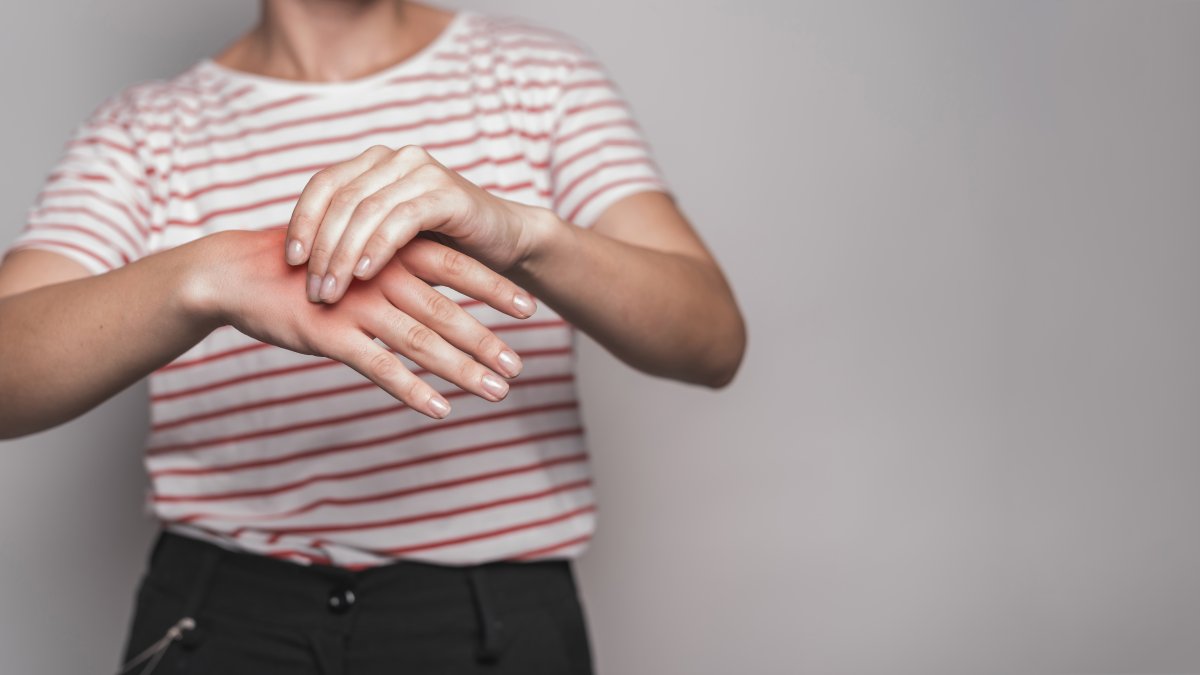 mid-section-young-woman-having-pain-hand-against-gray-background